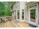 Wooden back deck with a chair, small table, neutral rug, windows, and entrance to home at 117 Willow View Ln, Canton, GA 30114