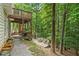 Multi-level backyard with deck, stairs, patio, fire pit, landscaping, and wooded backdrop at 117 Willow View Ln, Canton, GA 30114