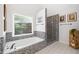Bright bathroom with mosaic-tile accent, soaking tub with window view, and glass-enclosed shower at 117 Willow View Ln, Canton, GA 30114