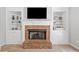 Close up of a cozy brick fireplace flanked by white built-in shelves and a mounted TV at 117 Willow View Ln, Canton, GA 30114