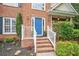 Close-up of a charming home's front door with brick steps, white railings, and colorful landscaping at 117 Willow View Ln, Canton, GA 30114