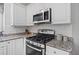Featuring gas range, microwave, and granite countertops, this kitchen is move-in ready at 117 Willow View Ln, Canton, GA 30114