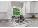 Close up of kitchen sink with granite countertops and large window with wooded view at 117 Willow View Ln, Canton, GA 30114