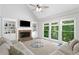 Bright living room with a brick fireplace, built-in shelving, a ceiling fan, and large windows with green view at 117 Willow View Ln, Canton, GA 30114