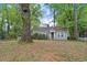 Single-story home nestled among large trees with a natural, leafy lawn at 2505 Mellville Ave, Decatur, GA 30032