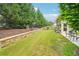 Expansive backyard with lush lawn, privacy fence, and stone retaining wall at 332 Rosshandler Rd, Suwanee, GA 30024