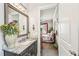 Bathroom with a view of the bedroom, featuring a single vanity, framed mirror, and neutral color scheme at 332 Rosshandler Rd, Suwanee, GA 30024