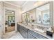 Bathroom featuring a vanity with granite countertop, large mirror, and elegant lighting at 332 Rosshandler Rd, Suwanee, GA 30024