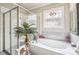 Bathroom boasts a shower, tub, and stained glass window at 332 Rosshandler Rd, Suwanee, GA 30024