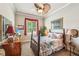 Comfortable bedroom with a ceiling fan, patterned bedspread, and a window with red curtains at 332 Rosshandler Rd, Suwanee, GA 30024