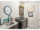 Well-equipped laundry room with sink, granite counters, overhead cabinet and modern washer and dryer at 332 Rosshandler Rd, Suwanee, GA 30024