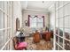 Bright home office featuring a wooden desk, French doors, and a patterned rug at 332 Rosshandler Rd, Suwanee, GA 30024