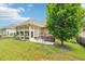 Enclosed patio area with hot tub, seating, and a mature shade tree in well maintained backyard at 332 Rosshandler Rd, Suwanee, GA 30024