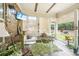 Bright sunroom with brick accent wall, wood beam ceiling, and view to backyard at 332 Rosshandler Rd, Suwanee, GA 30024