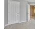 Hallway featuring white doors, neutral walls, and carpet flooring, providing access to other areas of the home at 4713 Liberty Square Dr, Acworth, GA 30101