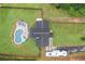 Aerial view of a home with in-ground pool, patio area, black roof, and a RV parked in the driveway at 5745 Westwood Dr, Cumming, GA 30040