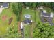 Aerial view of the property, lush green grass, large trees, a home, and an in-ground pool at 5745 Westwood Dr, Cumming, GA 30040
