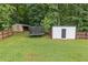 Well-maintained backyard with green grass, a fenced-in perimeter, storage shed, and a trampoline at 5745 Westwood Dr, Cumming, GA 30040