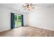 Bedroom featuring wood-look floors, ceiling fan, and large window at 5745 Westwood Dr, Cumming, GA 30040