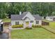 Charming home with white siding, a dark roof, and a bright yellow front door at 5745 Westwood Dr, Cumming, GA 30040