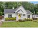 Charming white home with a black roof, black shutters, a yellow front door and lush green lawn at 5745 Westwood Dr, Cumming, GA 30040