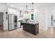 Open kitchen with stainless appliances, white cabinets, and center island at 5745 Westwood Dr, Cumming, GA 30040