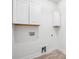 Convenient laundry room with white cabinetry and modern washer/dryer hookups at 5745 Westwood Dr, Cumming, GA 30040