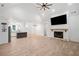 Spacious living room featuring a fireplace, ceiling fan, and open kitchen with an island at 5745 Westwood Dr, Cumming, GA 30040