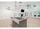 Modern living area with a kitchen island, fireplace, and abundant natural light at 5745 Westwood Dr, Cumming, GA 30040