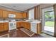 Traditional kitchen with wood cabinets, white appliances, and a view to the backyard at 1003 Dunedin Trl, Woodstock, GA 30188