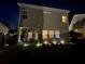 Backyard view of home at night, showcasing outdoor patio area and landscape lighting at 106 Cessna Dr, Canton, GA 30114