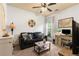 A cozy living room with a sofa, decorative pillows, a ceiling fan, and a work space by the window at 106 Cessna Dr, Canton, GA 30114