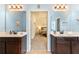 Dual sink main bathroom with dark wood cabinets, large mirrors and contemporary light fixtures at 106 Cessna Dr, Canton, GA 30114