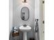 Stylish powder room featuring a pedestal sink, oval mirror and modern lighting fixtures at 106 Cessna Dr, Canton, GA 30114