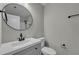 Bathroom with single vanity featuring white cabinets, a black faucet, and a round mirror at 2535 Brookgate Xing, Ellenwood, GA 30294