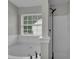 Bathroom with soaking tub and shower featuring white tiling and a window at 2535 Brookgate Xing, Ellenwood, GA 30294