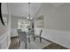 Dining room with wainscoting, a modern chandelier, and a glass table set for four at 2535 Brookgate Xing, Ellenwood, GA 30294