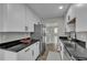 Bright kitchen with stainless steel appliances and dark granite countertops and view to the staircase at 2535 Brookgate Xing, Ellenwood, GA 30294