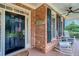 Welcoming front porch featuring a classic black door, brick accents, and comfortable rocking chairs at 403 Hidden Hills Ct, Canton, GA 30115