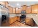 Renovated kitchen featuring stainless steel appliances, granite countertops, and stylish wood cabinets at 100 Trailside Way, Hiram, GA 30141
