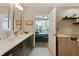 Modern bathroom featuring dual vanities with quartz countertops, dark wood cabinets and doorway to bedroom at 1080 Peachtree Ne St # 1402, Atlanta, GA 30309