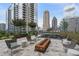 Patio area includes an outdoor fireplace, seating and city views at 1080 Peachtree Ne St # 1402, Atlanta, GA 30309