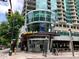 Exterior of building featuring Taco Mac Irish Pub with unique glass architectural design, plus pedestrian traffic at 1080 Peachtree Ne St # 1402, Atlanta, GA 30309