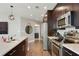 Contemporary kitchen featuring stainless steel appliances, quartz countertops, and dark wood cabinets at 1080 Peachtree Ne St # 1402, Atlanta, GA 30309