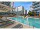 Beautiful outdoor pool area with lounge chairs, tables, and umbrellas in a modern condominium complex at 1080 Peachtree Ne St # 1402, Atlanta, GA 30309