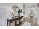 Welcoming foyer with wood floors, stylish console table, round mirror, and an inviting glimpse into the living spaces at 16 Dovecrest Way, Acworth, GA 30101