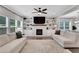 Bright living room features a fireplace, built-in shelving, ceiling fan, and large windows for ample natural light at 16 Dovecrest Way, Acworth, GA 30101