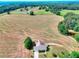 Aerial view of home and acreage with beautiful green space and a serene pond at 259 Hwy 11, Social Circle, GA 30025