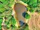 Beautiful aerial view of a private pond surrounded by mature trees and open land at 259 Hwy 11, Social Circle, GA 30025