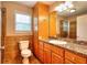 Bathroom showcasing oak cabinetry, granite countertops, and a vanity mirror at 259 Hwy 11, Social Circle, GA 30025